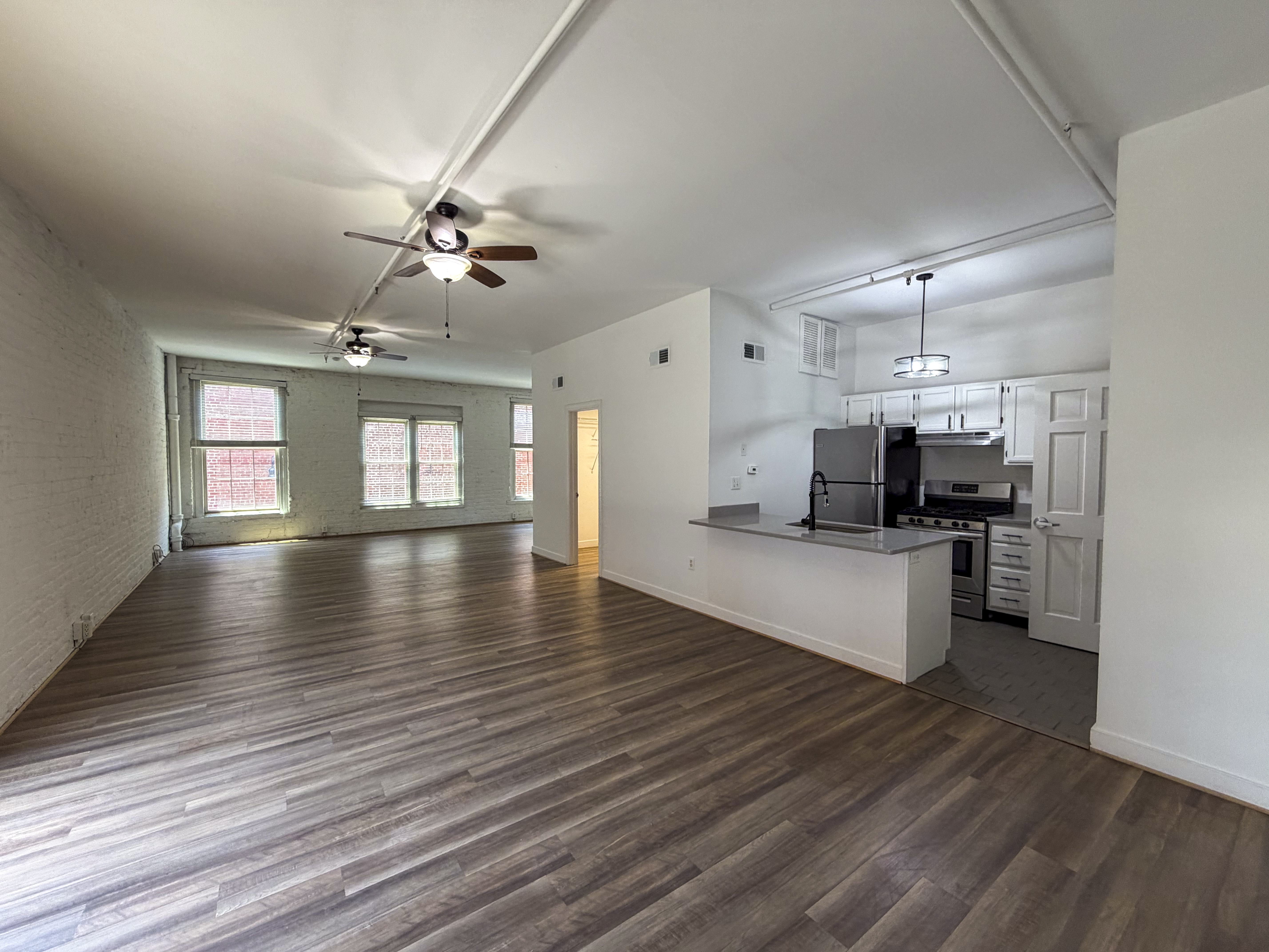 A room with wooden floors and a ceiling fan.